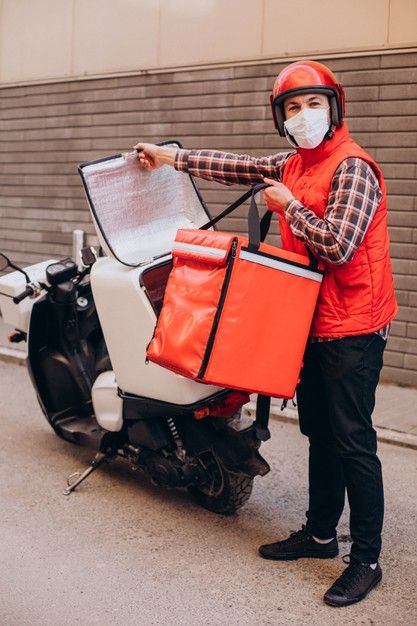 food delivery boy driving scooter with box with food and wearing mask free photo
